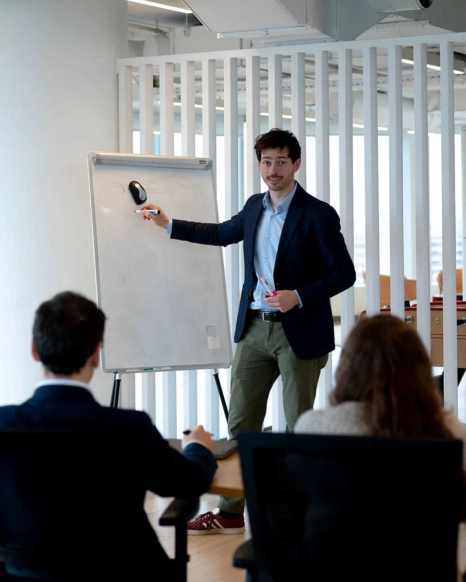 Un ingénieur Ionect anime une formation sur l'hydrogène vert au paperboard, avec des participants autour d'une table